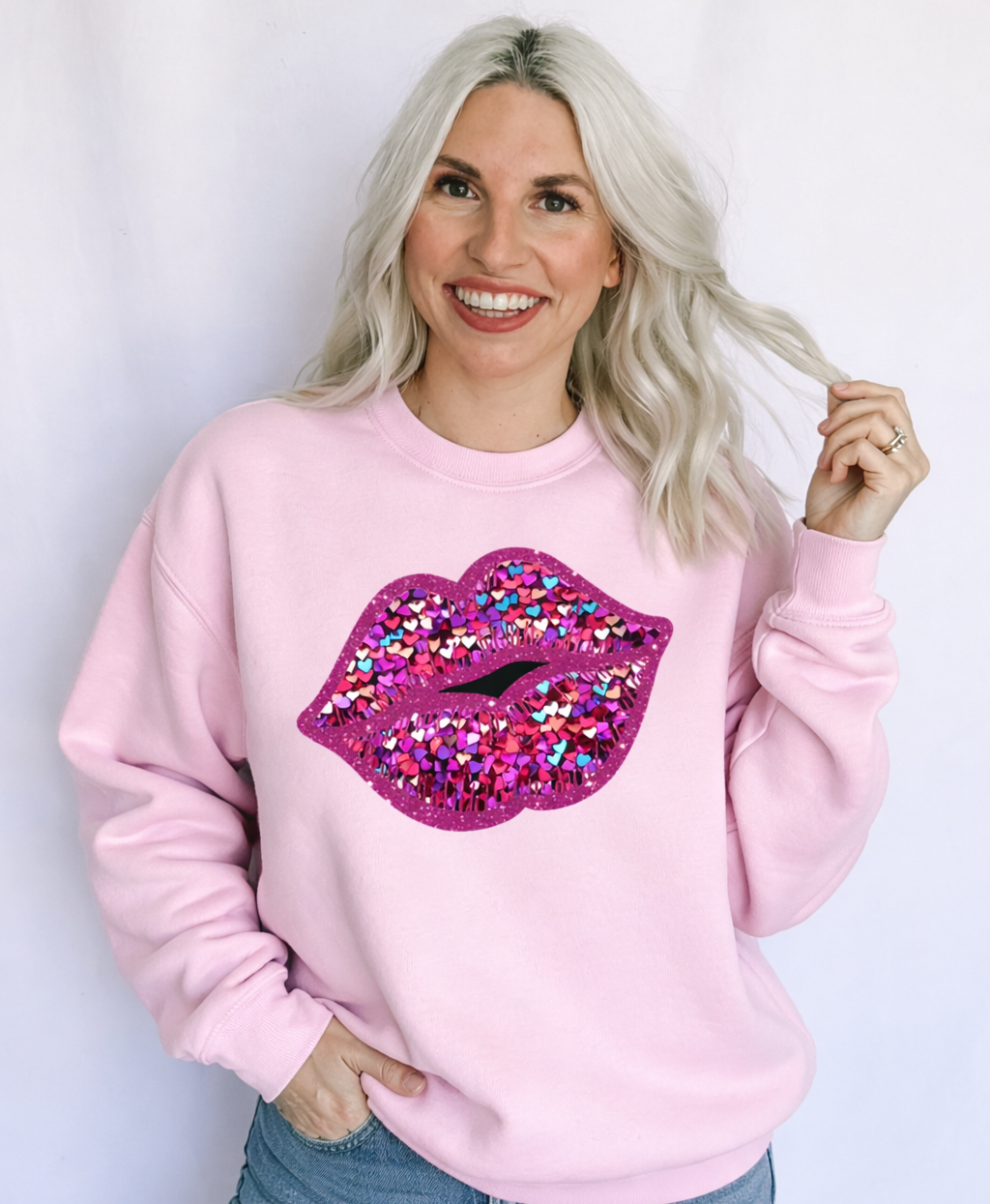 Woman wearing a pink sweatshirt with a colorful lip design on a white background