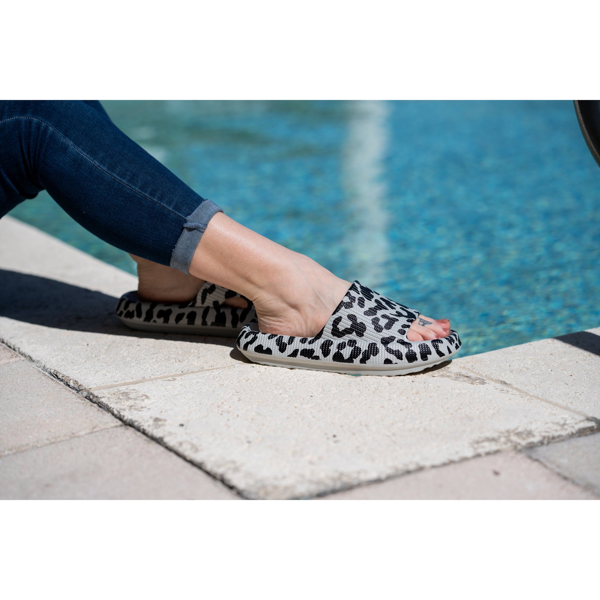 Gray leopard-print beach slides with a bold spotted pattern and easy slip-on design.