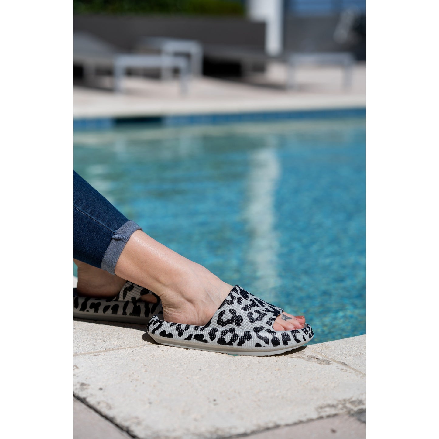 Gray leopard-print beach slides with a bold spotted pattern and easy slip-on design.